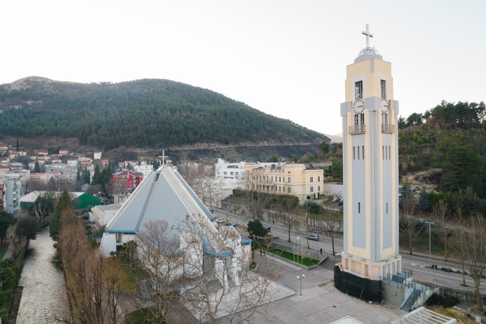Mostarska katedrala i zvonik uz rijeku Radobolju, ispod zelenog brda